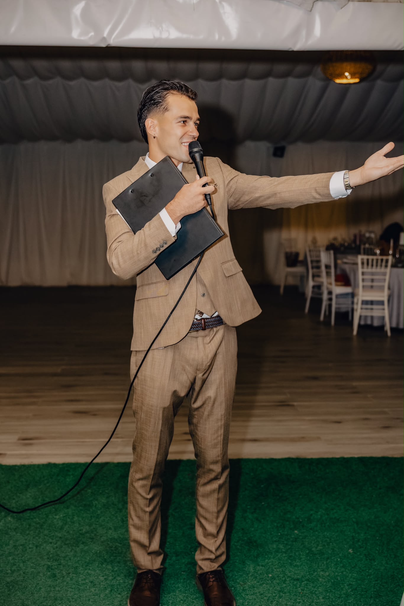 Vova hosting Roman and Anna’s reception in a tan suit